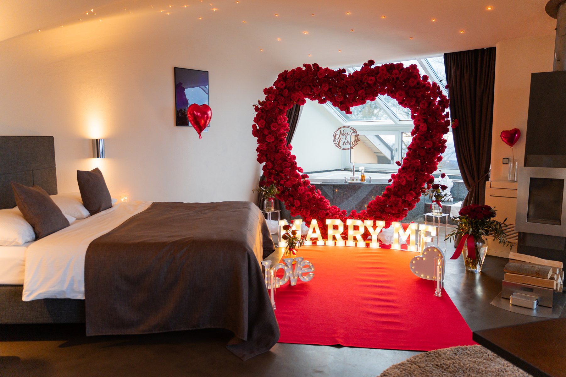Hotel suite decorated with a red rose heart and Marry Me letters
