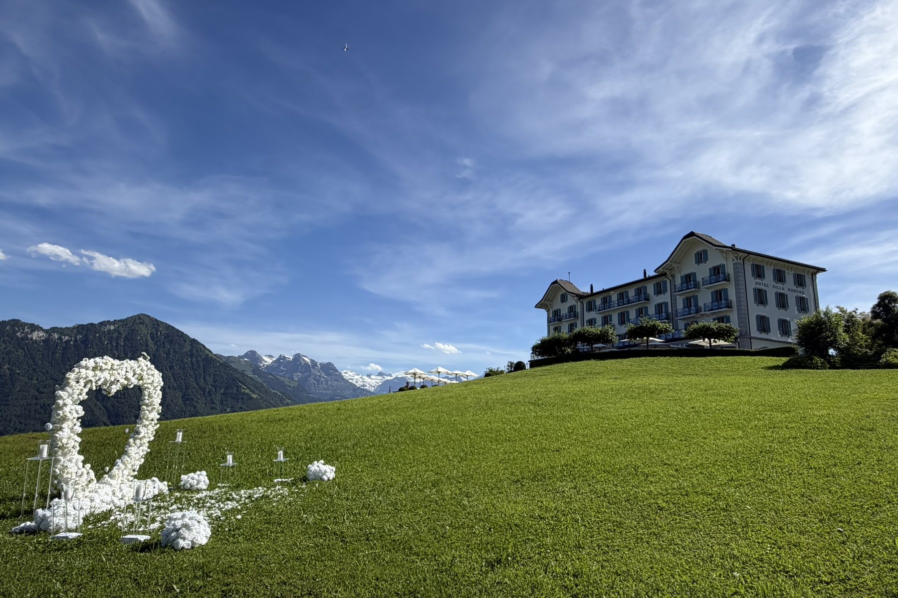 White floral heart on a meadow in front of an alpine hotel above Lake Lucerne